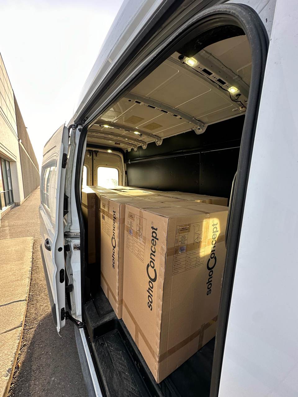 Boxed chairs loaded and strapped in the back of the Moving United van