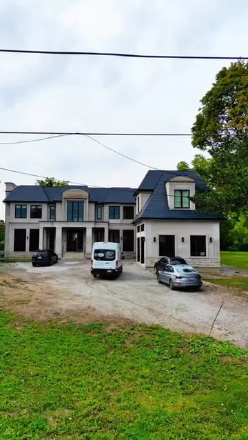 A white moving van in the driveway of a large new house