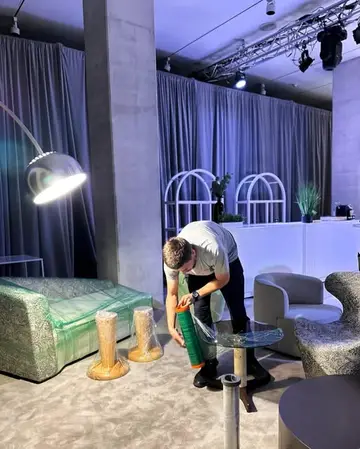 A mover setting up lounge furniture at an event venue